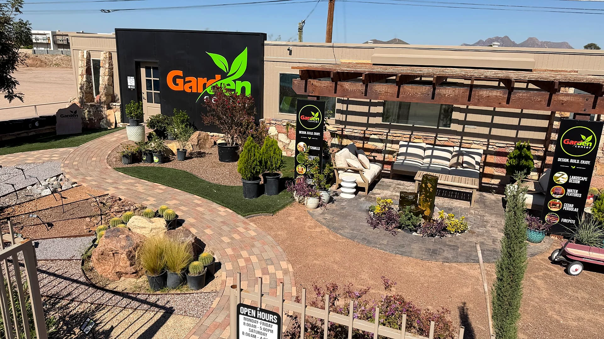 Garden Center of Las Cruces display yard with a curved paver walkway, cedar pergola over a stone fountain patio, artificial turf, decorative rock beds, and desert plants in Las Cruces, NM Garden Center of Las Cruces display yard with a curved paver walkway, cedar pergola over a stone fountain patio, artificial turf, decorative rock beds, and desert plants in Las Cruces, NM